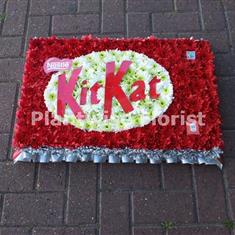 A Kit Kat Wreath Made In Flowers For A Funeral